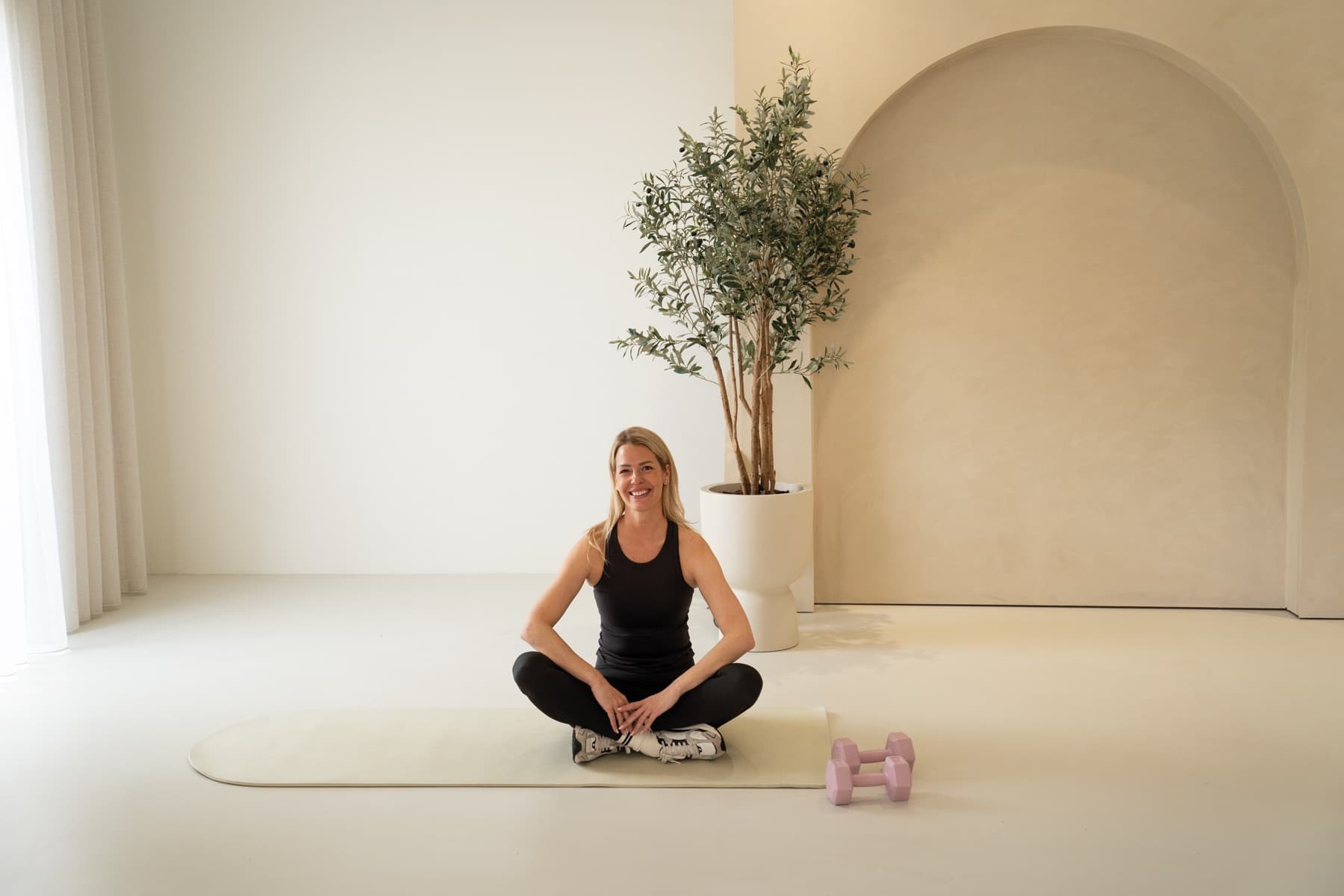 Nynke, HIIT-trainer, zittend op de mat